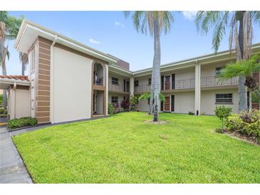 Charming condo complex with well-maintained lawn and beautiful palm trees at 19029 Us Highway 19 N # 3-1, Clearwater, FL 33764
