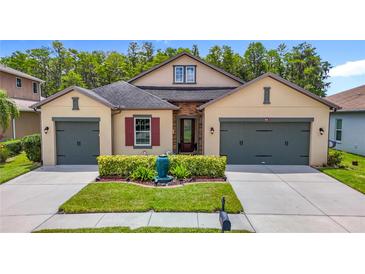 Inviting home with a well-kept lawn, dual garage, and charming architectural details at 1958 Marshberry Ct, Trinity, FL 34655
