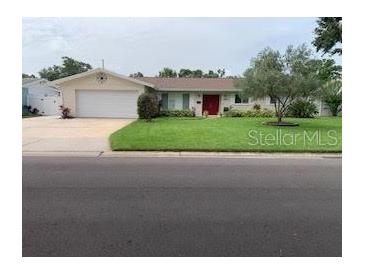 Charming single-story home with a well-maintained lawn, a two-car garage, and a welcoming red front door at 6474 29Th N Ave, St Petersburg, FL 33710