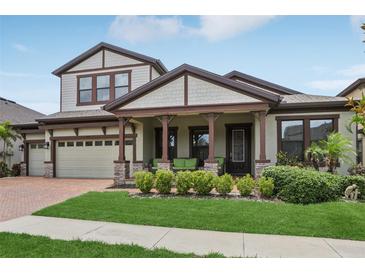 Charming two-story home with a well-manicured lawn, brick driveway, and welcoming front porch with decorative columns at 808 Vittorio Pl, Brandon, FL 33511