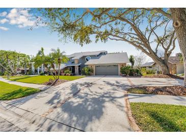 Charming home featuring mature landscaping, a brick-lined driveway, and a two-car garage at 9011 Baywood Park Dr, Seminole, FL 33777