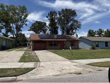 Charming single-story brick home with solar panels, a one-car garage and a well-maintained lawn at 902 Marshall St, Clearwater, FL 33755