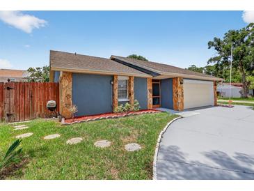 Charming home featuring stone accents, a well-maintained lawn, and stepping stones leading to the entrance at 11320 Partridge Dr, Tampa, FL 33625