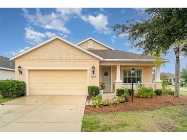 Charming single-story home with a manicured lawn, attached garage, and inviting front porch at 11849 Forest Park Cir, Bradenton, FL 34211