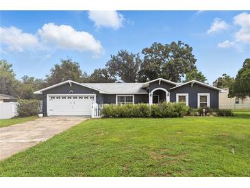 Charming single-story home featuring a well-manicured lawn, attached garage, and a welcoming entrance at 37331 Hickory Hill Ln, Dade City, FL 33525