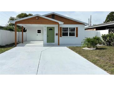 Charming renovated home featuring a carport, freshly painted exterior, and a bright green front door at 5151 7Th N Ave, St Petersburg, FL 33710