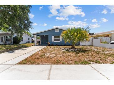 Charming blue home with a well-manicured yard and covered entrance at 546 90Th N Ave, St Petersburg, FL 33702