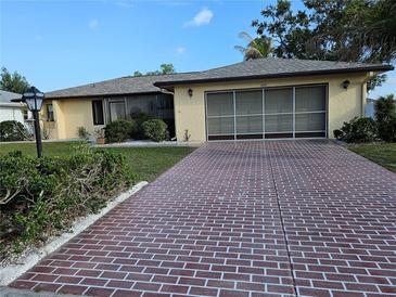 Charming single-story home with a well-maintained lawn, brick driveway, and attached garage at 1510 Flamingo Ln, Sun City Center, FL 33573