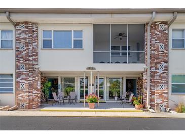 Inviting condo building exterior with brick accents and a charming entrance with seating at 416 73Rd N Ave # 205, St Petersburg, FL 33702