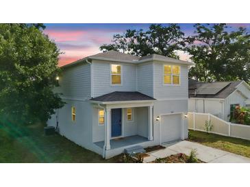 Charming two-story home with a light blue exterior, covered porch, and well-maintained landscaping at 4312 E Shadowlawn Ave, Tampa, FL 33610