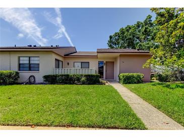 Charming single-story home with a well-maintained lawn, inviting walkway, and manicured landscaping at 50 Ingrid Pl # 50, Oldsmar, FL 34677