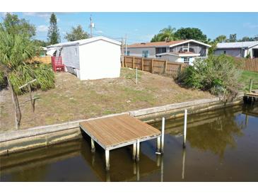 Exterior view of the waterfront property with a private wooden dock extending into the canal at 5824 Coventry Dr, Tampa, FL 33615