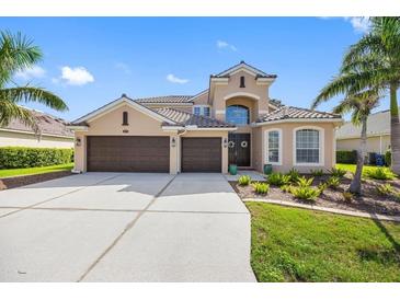 Charming two-story home with a three-car garage, a tile roof, and lush tropical landscaping at 1178 Fraser Pine Blvd, Sarasota, FL 34240