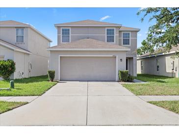 Charming two-story home features a two-car garage, well-maintained lawn, and neutral color scheme at 14403 Dunrobin Dr, Wimauma, FL 33598