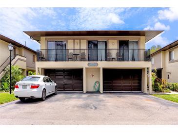 Two-story condo featuring a front-facing balcony, two garage doors, and off-street parking at 1881 Lichen Ln # B, Clearwater, FL 33760