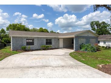 Charming single-story home featuring a stone facade, well-maintained landscaping, and an expansive driveway at 212 Gay Rd, Seffner, FL 33584