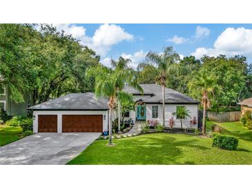 Well-maintained single-Gathering home with a lush lawn, landscaping and 3-car garage at 2435 Fox Forest Dr, Lutz, FL 33549