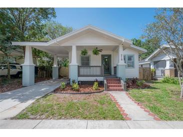 Charming bungalow with a cozy front porch and attached carport, showcasing curb appeal at 318 W Haya St, Tampa, FL 33603
