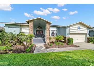 Charming single-story home with a welcoming entrance, beautiful landscaping, and a two-car garage at 338 7Th N Ave, Tierra Verde, FL 33715