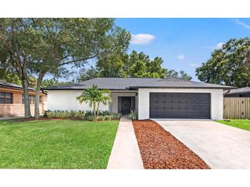 Charming single-story home with a well-manicured lawn and an attached two-car garage at 3408 W Swann Ave, Tampa, FL 33609