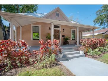 Charming single-story home with a welcoming front porch and beautifully landscaped front yard at 409 E Frances Ave, Tampa, FL 33602