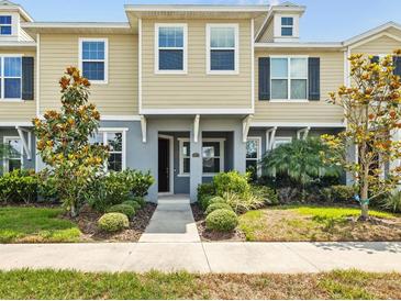 Charming townhome with a well-maintained lawn and beautiful landscaping adding curb appeal at 5170 Sea Mist Ln, Wesley Chapel, FL 33545