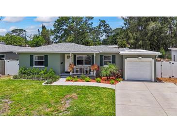 Charming single-story home featuring a well-manicured lawn and a welcoming front porch with decorative landscaping at 9000 Bay Ne St, St Petersburg, FL 33702