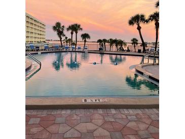 Outdoor pool area with palm trees offers serene waterfront living and relaxing sunsets at 100 Bluff View Dr # 511C, Belleair Bluffs, FL 33770