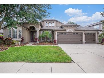 Charming single-story home with well-manicured lawn and a three-car garage and beautiful landscaping at 1342 Salmonberry St, Wesley Chapel, FL 33543
