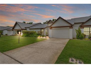 Charming one story home featuring a lush landscaped yard and attached two car garage at 1401 Camelot Ct, Palm Harbor, FL 34684