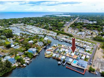 Enjoy this aerial view of waterfront community with docks, boats, and gulf access at 2011 Ketch Cir, Palm Harbor, FL 34683