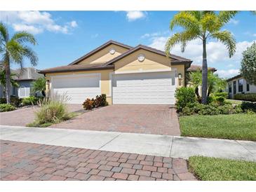 Charming single-Gathering home featuring a spacious two-car garage, well manicured landscaping, and a brick driveway at 21008 Fetterbush Pl, Venice, FL 34293
