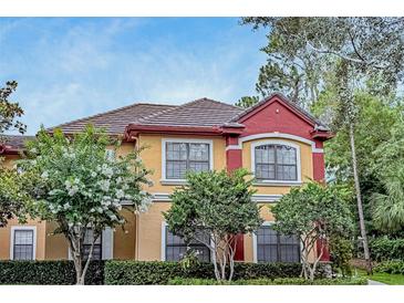 Charming exterior with colorful stucco, tile roof, and lush landscaping at 2171 Portofino Pl # 27-2725, Palm Harbor, FL 34683