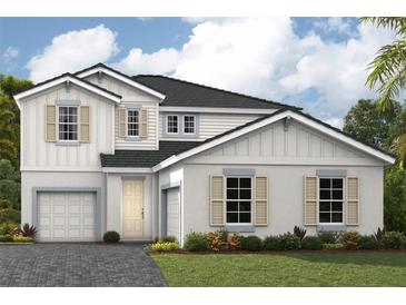 Charming two-story home with a gray roof, brick driveway, two-car garage and beautifully landscaped front yard at 3806 Farm Garden Ct, Lakewood Ranch, FL 34211