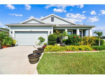 Charming single-story home with well-manicured lawn and landscaping under a clear, blue sky at 8174 Wheat Stone Dr, Zephyrhills, FL 33540