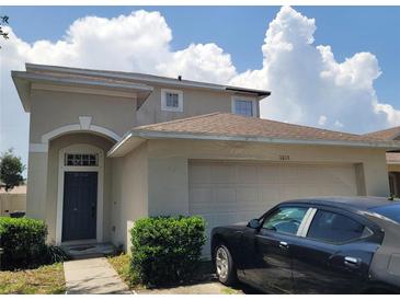 Charming two-story home featuring an attached garage and lush green bushes at the front at 1015 Windton Oak Dr, Ruskin, FL 33570