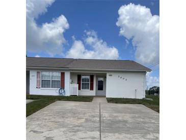 Charming single-story villa with a white exterior, red shutters, and a well-maintained front yard at 3007 Wainwright Ct, New Port Richey, FL 34655