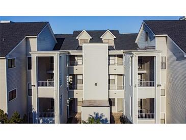 Exterior view of a light gray condominium building with multiple balconies, and a dark roof at 3127 W Sligh Ave # 303B, Tampa, FL 33614