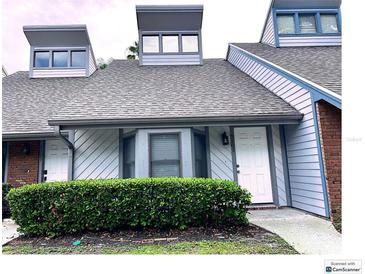 Charming condo with gray roof, white siding, and a well-maintained green hedge at 5203 Oak Charter Ct # 5203, Temple Terrace, FL 33617