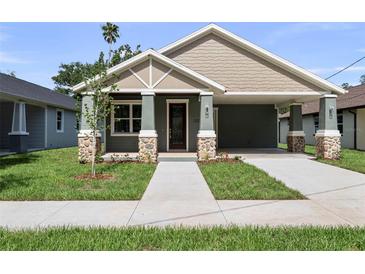 Charming single-story home with a covered porch, stone accents, and a well-manicured lawn at 5703 N 20Th St, Tampa, FL 33610