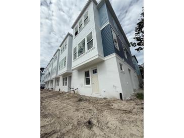 Modern townhome with white stucco and blue siding, featuring large windows and contemporary design at 6605 N Nebraska Ave # 11, Tampa, FL 33604