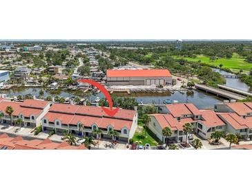 A captivating aerial view showcasing a beautiful red-roofed townhome community and the lovely waterfront area it neighbors at 2363 Hanover Dr, Dunedin, FL 34698