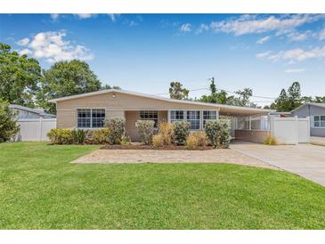 Charming home boasts a well-manicured lawn and a welcoming brick walkway, leading to a covered carport at 2861 Pinellas Point S Dr, St Petersburg, FL 33712
