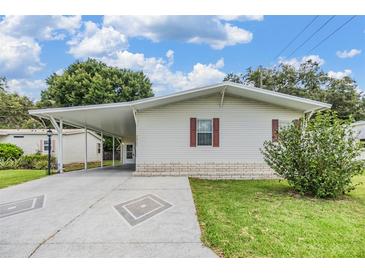 Charming single-story home featuring carport, manicured lawn, and lovely landscaping at 36731 Tara Ave, Zephyrhills, FL 33542