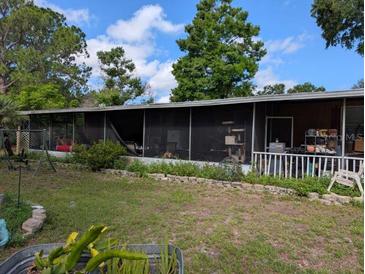 Exterior view of a home featuring a screened porch with ample seating and a well-maintained lawn at 12709 Greenland Dr, Riverview, FL 33579
