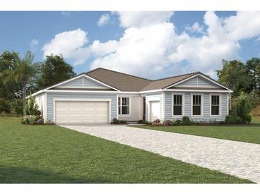Charming single-story home with a well-manicured lawn, two-car garage, and stylish light blue and white siding at 18421 Vista Park Ter, Venice, FL 34293