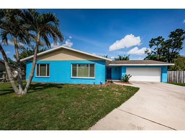 Bright blue single-story home with a well-maintained lawn and a palm tree in the front yard at 2020 58Th N Way, Clearwater, FL 33760