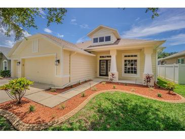 Charming home with a well-manicured lawn, neat mulch beds, and a welcoming covered entryway at 2957 Hickory Grove Dr, Valrico, FL 33596