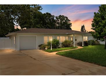 Charming single-story home with a well-maintained lawn, driveway, and attached garage at dusk at 3839 18Th N Ave, St Petersburg, FL 33713