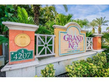 Grand Key Condominiums entrance sign surrounded by lush landscaping and tropical palm trees on a sunny day at 4207 S Dale Mabry Hwy # 2105, Tampa, FL 33611